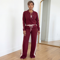 Klara woven two-piece set in burgundy and cream featuring zip-front jacket and flare pants with drawstring waist