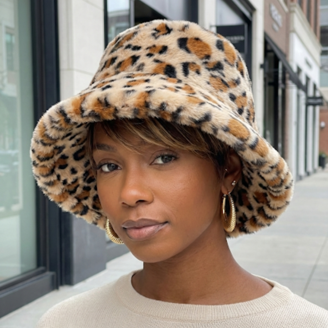Woman wearing a leopard print bucket hat on a city street.
