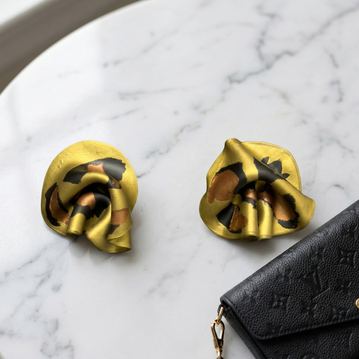 Leopard mini statement stud earrings on marble with luxury handbag