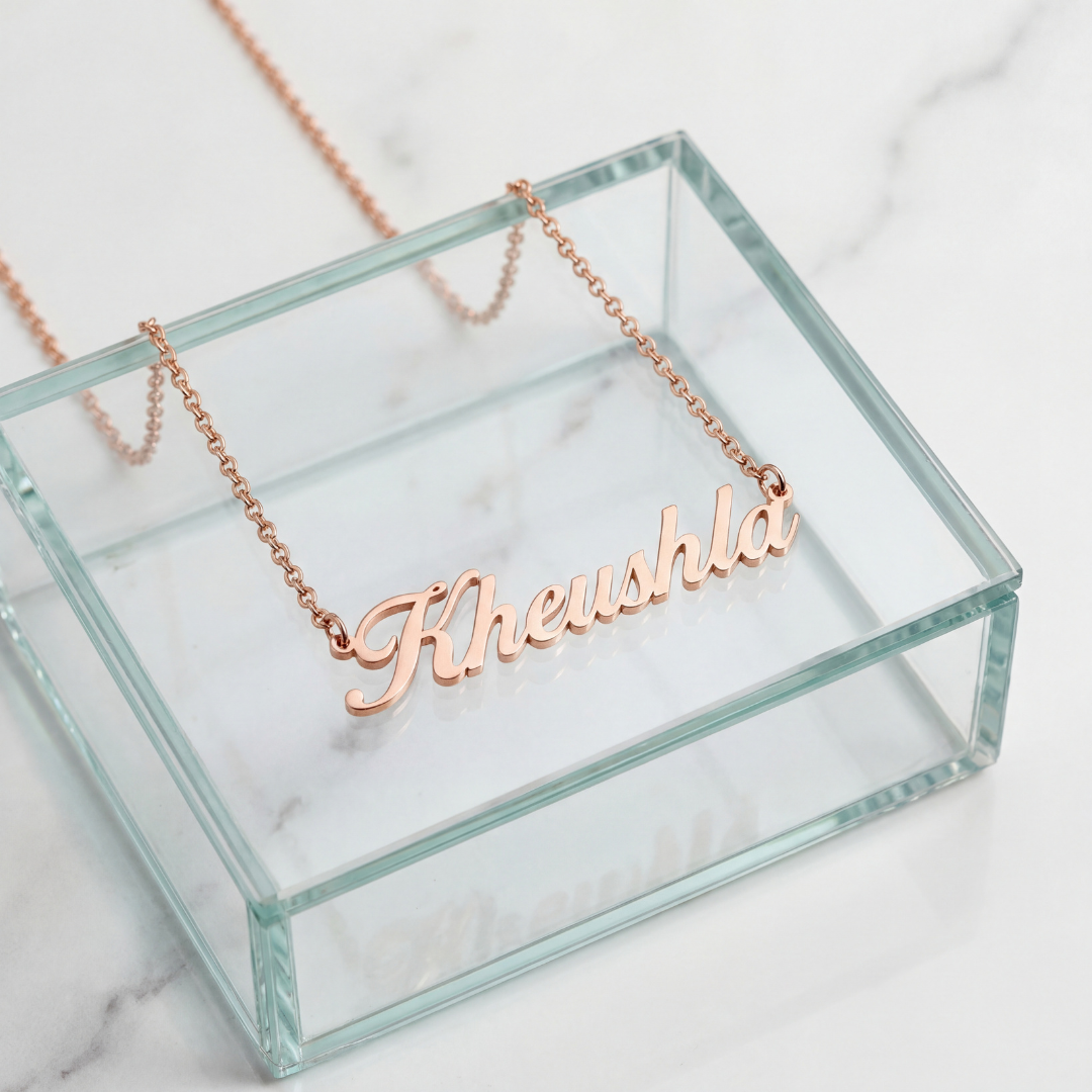 Rose gold cursive personalized name necklace spelling Kheushla on a glass jewelry box