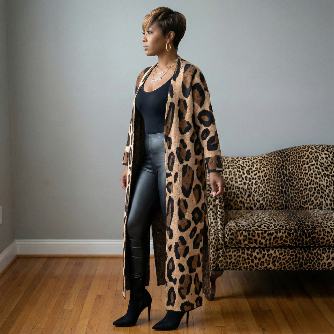Woman wearing a leopard print cardigan in a room with a leopard print couch.
