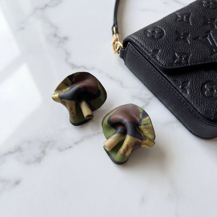 Camo mini statement stud earrings on marble with luxury handbag