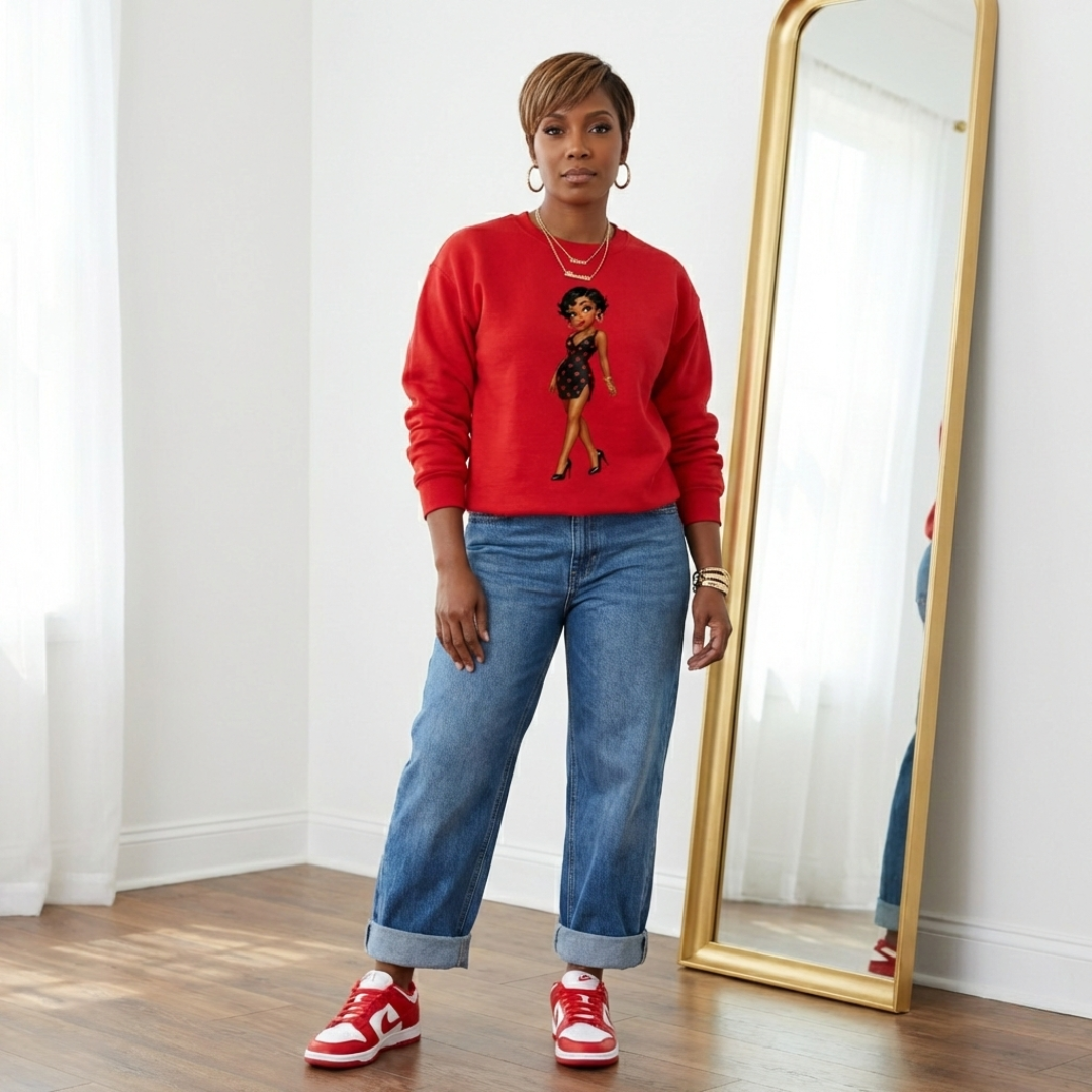 Red Valentine graphic sweatshirt styled with cuffed wide-leg jeans and red and white Nike Dunks on a confident African American woman in a modern white room.