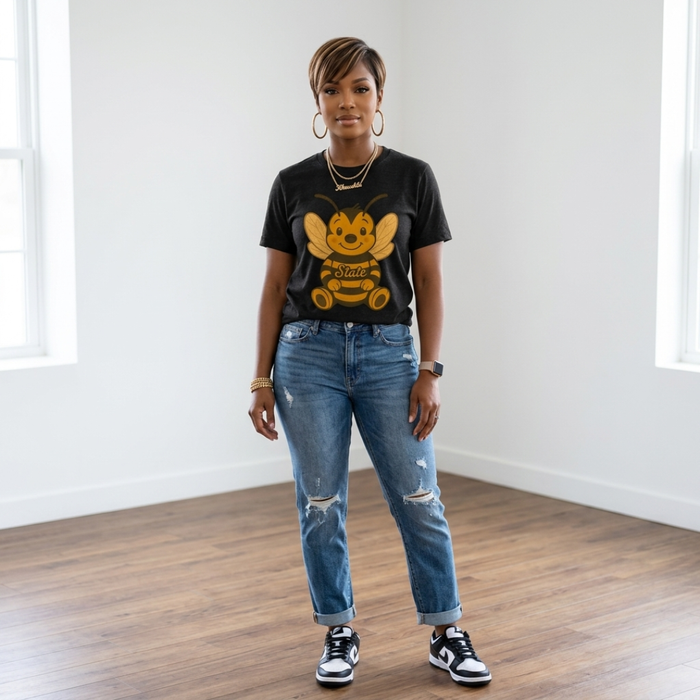 African American woman wearing the Hornet Game Day Tee in black heather with cuffed distressed jeans and black and white sneakers