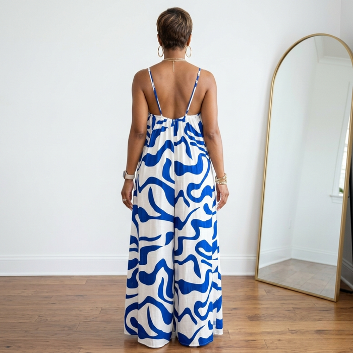 Back and white view of blue wide leg spaghetti strap jumpsuit with relaxed oversized fit and full-length hem.