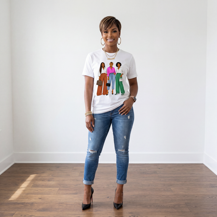 African American woman wearing The Trio graphic t-shirt with distressed cuffed skinny jeans and black pumps in a white room with hardwood flooring.